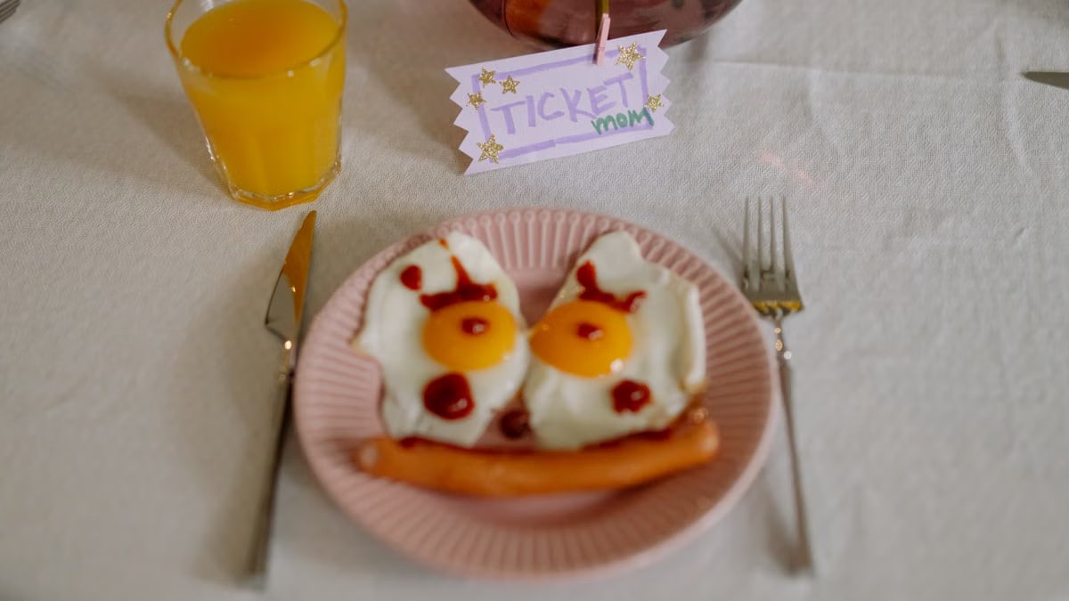 Inviting breakfast with fried eggs, sausage, and orange juice on a festive table.